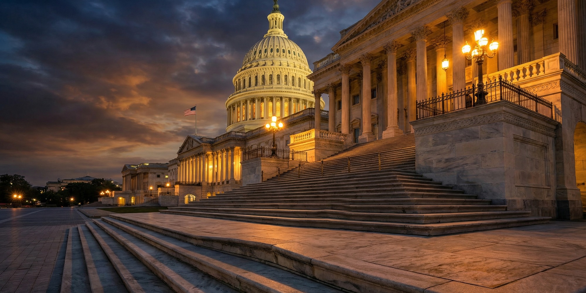 United States Capitol building dome at dusk with amber light across marble steps and American flag